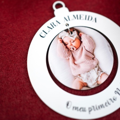 Porta-chaves branco com foto de bebé e texto CLARA ALMEIDA e O meu primeiro elo sobre fundo vermelho.