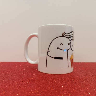 Caneca branca com desenho de personagem e balde de pipocas