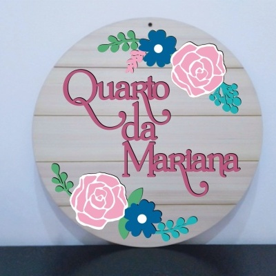 Placa redonda de madeira com texto em rosa e flores coloridas