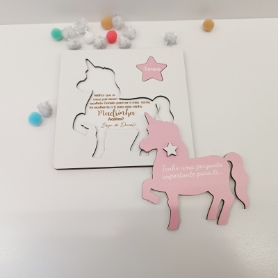 Cartão unicórnio branco com texto e estrelas rosas, pompons espalhados no fundo branco