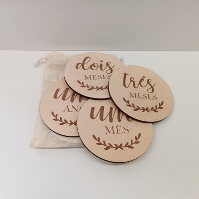 Placas de madeira com inscrições de meses em português e um saco de tecido.
