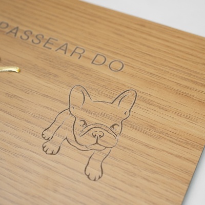 Prancha de madeira com gravação de um cão e texto em cinzento