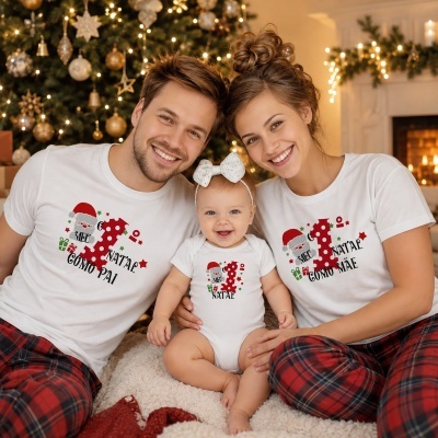Família vestindo pijamas de Natal com frases comemorativas e uma árvore de Natal ao fundo