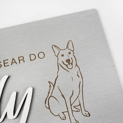 Placa cinzenta com desenho de cão e texto em relevo