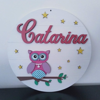 Placa redonda branca com nome Catarina em letras rosas e coruja colorida sentada num ramo com estrelas amarelas