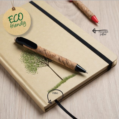 Caderno ecológico com caneta em mesa de madeira clara