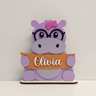 Objeto decorativo hipopótamo lilás com óculos e placa com nome Olivia