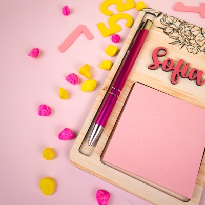 Placa de madeira com caneta rosa, notas autocolantes e palavra sofia, com pedras decorativas coloridas