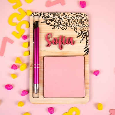 Bloco de notas em suporte de madeira com caneta rosa e a palavra Sofia em verde