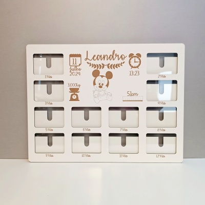 Painel branco com molduras para fotos mensais e texto personalizado com nome e dados do bebé