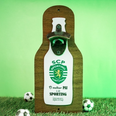 Abridor de garrafas de parede com emblema do Sporting Portugal e texto alusivo a pai, em base de madeira sobre relva artificial