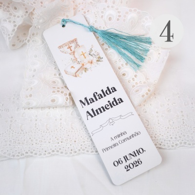 Marcador de páginas branco com tassel azul sobre tecido de renda branca