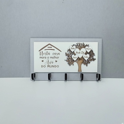 Cabideiro de parede cinzento com placa decorativa em madeira branca e castanha com árvore da família e texto em português