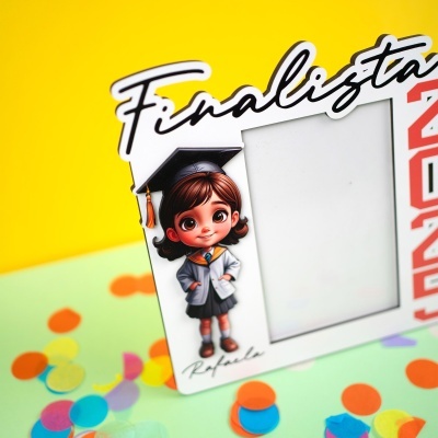 Moldura branca de fotografia com boneca vestida com bata académica e texto Finalista
