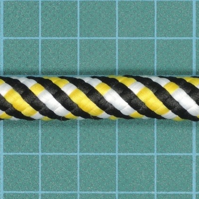 Corda torcida preta, amarela e branca sobre fundo de grade verde