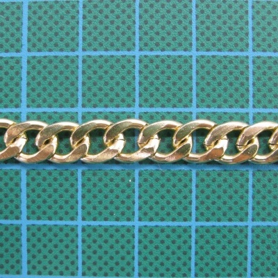 Corrente dourada sobre tapete de corte verde com grelha azul