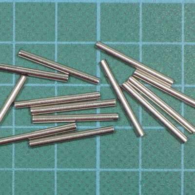 Pinos metálicos prateados em superfície quadriculada verde