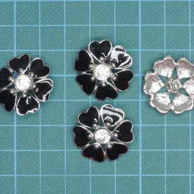 Quatro botões florais metálicos em fundo quadriculado azul