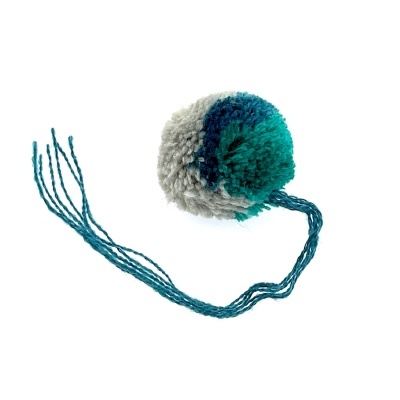 Pompom de lã tricolor com fios soltos verdes.