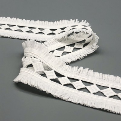 Fita branca decorativa com padrão em losangos e franjas