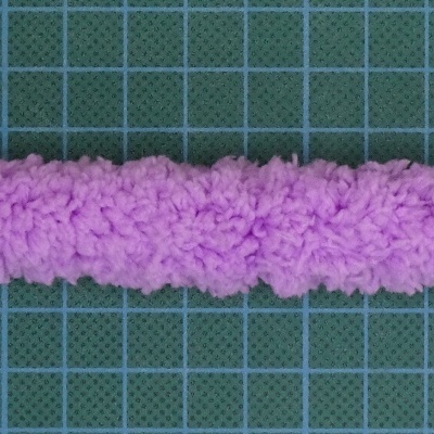 Tubo felpudo cor-de-rosa sobre fundo verde com grade azul
