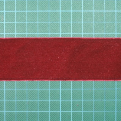 Faixa de tecido vermelho sobre base de corte verde com grelha branca