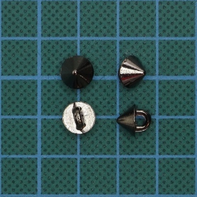 Tachas metálicas em forma de cone sobre fundo verde com grade azul
