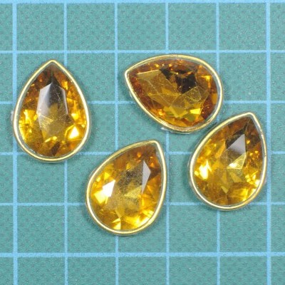 Quatro pedras amarelas artificiais em forma de gota com borda metálica