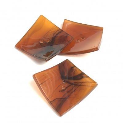 Três pratos pequenos quadrados de vidro com padrão marmoreado castanho e âmbar