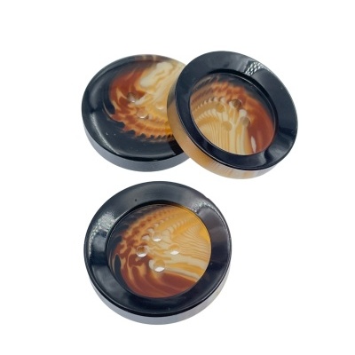 Conjunto de três botões redondos com bordas pretas e centro marmoreado castanho e bege