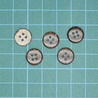 Cinco botões de cor castanha e bege sobre base azul quadriculada