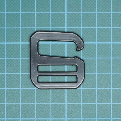 Clip metálico preto sobre superfície quadriculada verde