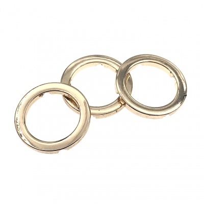 Três argolas metálicas douradas brilhantes sobre fundo branco