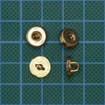 Botões metálicos dourados sobre superfície verde quadriculada azul