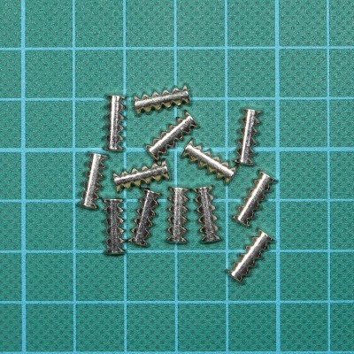 pequenos terminais metálicos prateados em superfície verde com grelha azul