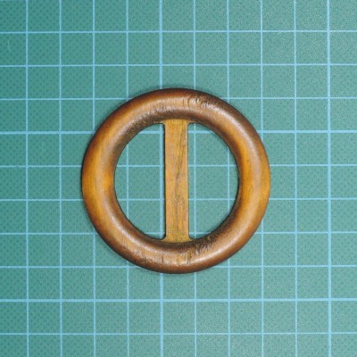 Argola redonda de madeira com barra vertical sobre fundo verde quadriculado