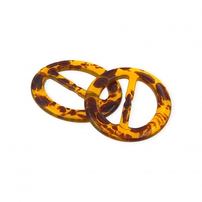 Duas fivelas redondas padrão tartaruga amarelo e castanho sobre fundo branco