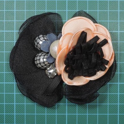 Broche floral preto e bege com detalhes texturizados e brilhantes