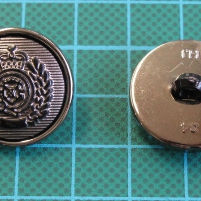 Botões metálicos redondos com padrão em relevo e superfície quadriculada verde.