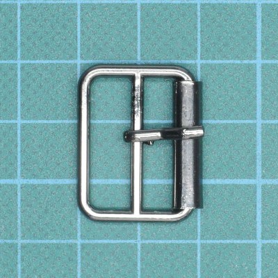 Fivela metálica prateada sobre fundo quadriculado