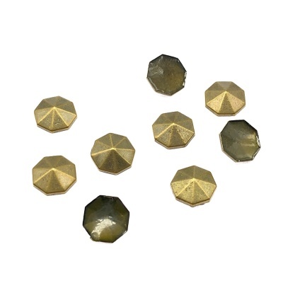 Tachas octogonais em metal dourado e resina verde num fundo branco