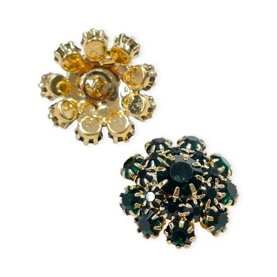 Dois botões redondos decorativos em metal dourado e pedras verdes escuras sobre fundo branco