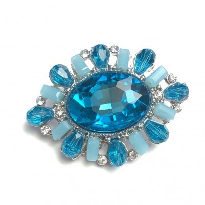 Broche com pedras azuis e pequenos cristais em base prateada
