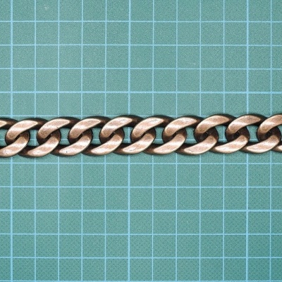 Corrente metálica cobre sobre fundo de grelha verde.