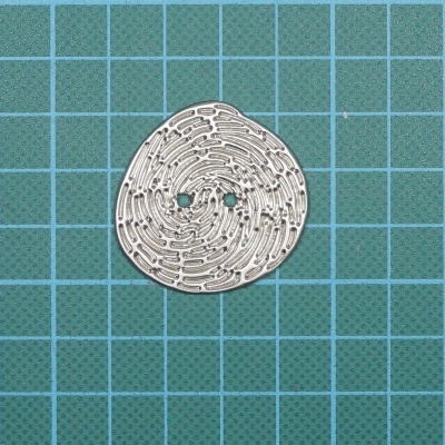 Placa metálica redonda com padrão de circuitos sobre fundo azul quadriculado