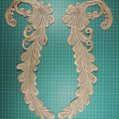 Aplicações de renda bege com padrão de folhas em fundo quadriculado verde