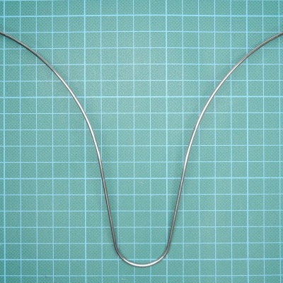 Antena metálica com fios finos sobre fundo quadriculado verde