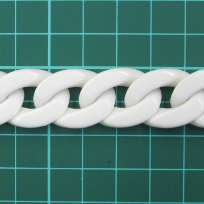 Corrente branca com elos grandes sobre fundo verde quadriculado