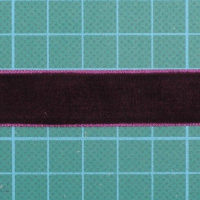 Fita de veludo vinho com bordas pink sobre fundo verde quadriculado