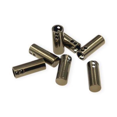 Peças cilíndricas metálicas douradas com orifícios, dispostas num fundo branco.